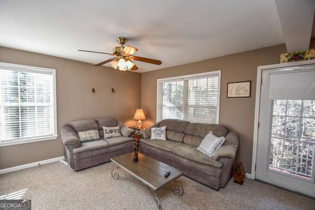 living area with light colored carpet, plenty of natural light, and baseboards