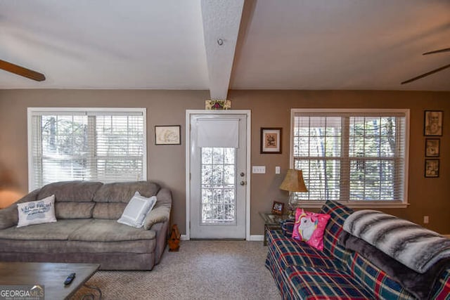 living room with beam ceiling, light colored carpet, ceiling fan, and baseboards