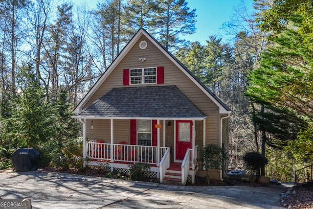 view of front of house with a porch and roof with shingles