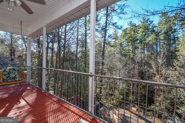 wooden terrace featuring covered porch and a ceiling fan