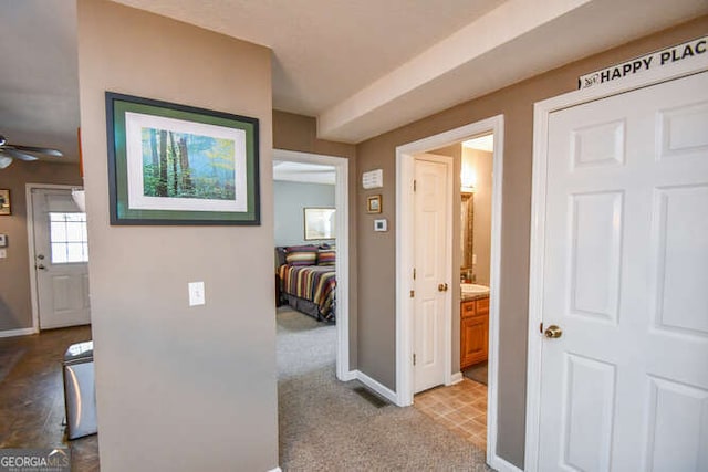 hallway with light carpet and baseboards