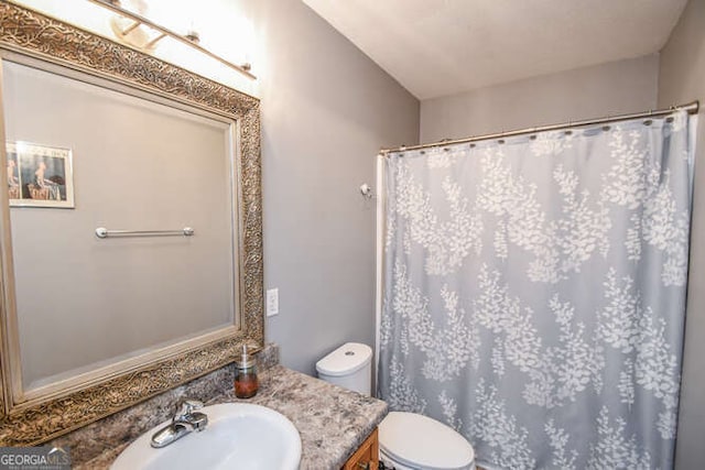 bathroom with toilet, a shower with shower curtain, and vanity