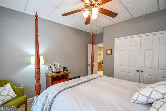 bedroom featuring ceiling fan, a closet, and a paneled ceiling