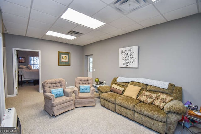 carpeted living room with a paneled ceiling, visible vents, and a healthy amount of sunlight