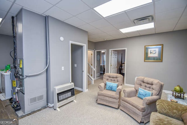 carpeted living area featuring heating unit, visible vents, washer / clothes dryer, and a drop ceiling