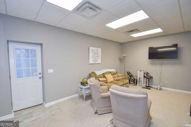 living room featuring light carpet, a paneled ceiling, visible vents, and baseboards