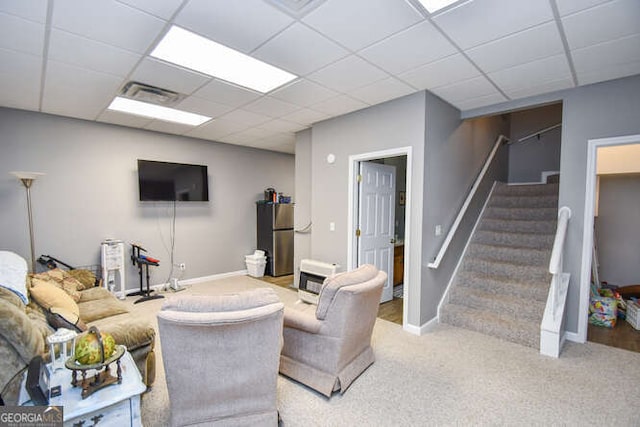 living room with baseboards, visible vents, a drop ceiling, stairs, and carpet floors