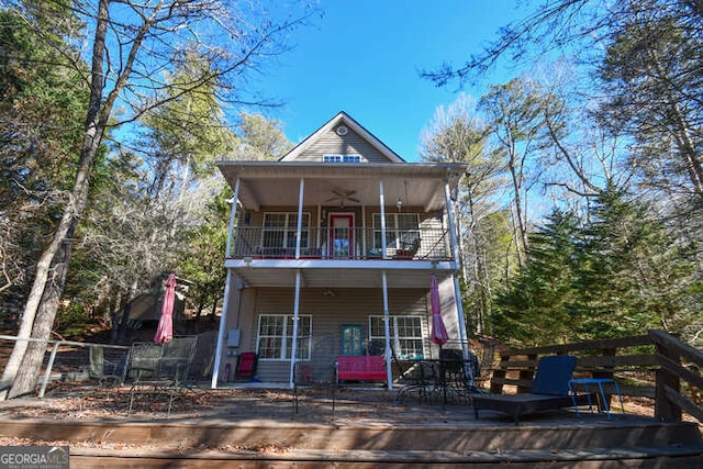 view of front of home featuring a balcony, a ceiling fan, and a wooden deck