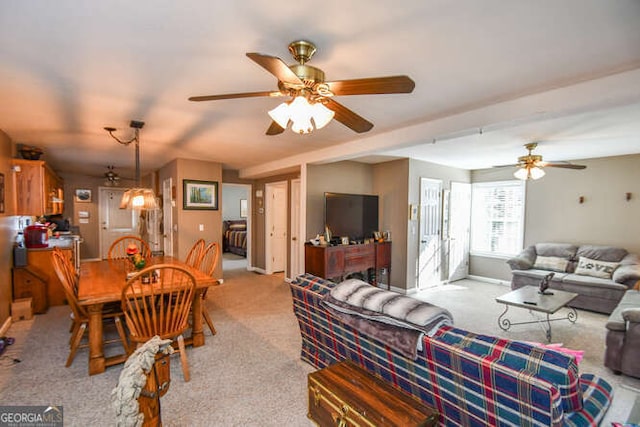 living area with light carpet, a ceiling fan, and baseboards