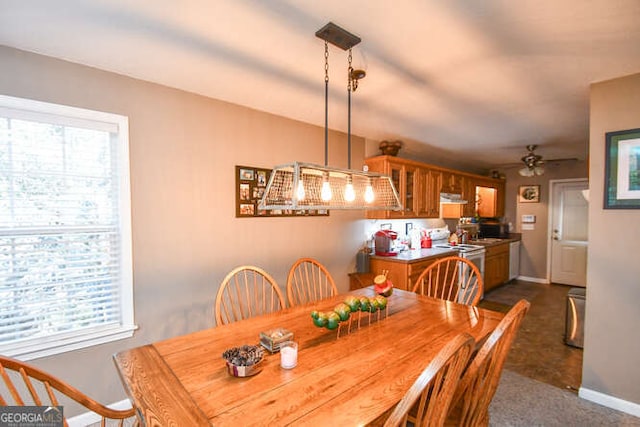 dining area featuring ceiling fan and baseboards