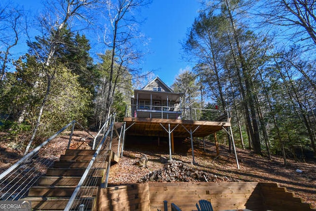 back of property featuring a deck and stairway