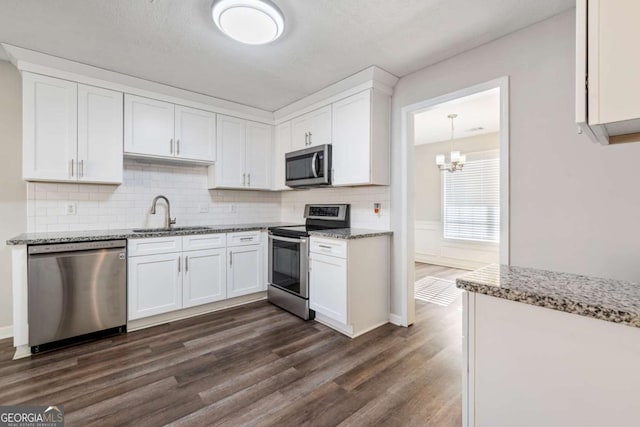 kitchen with appliances with stainless steel finishes, dark hardwood / wood-style flooring, sink, and white cabinets