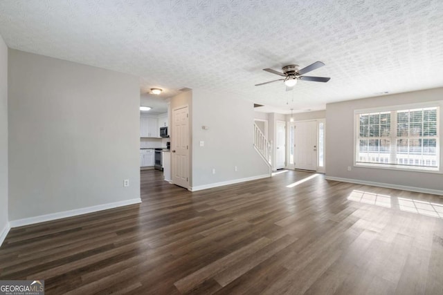 unfurnished living room with dark hardwood / wood-style flooring, ceiling fan, and a textured ceiling