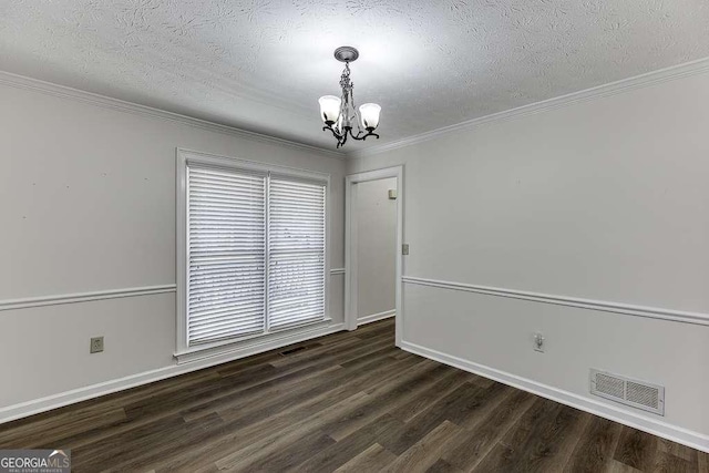 spare room with dark wood-type flooring, a textured ceiling, ornamental molding, and a notable chandelier