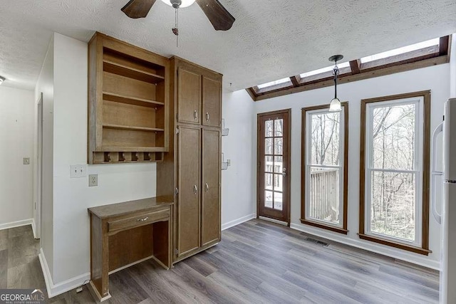 interior space featuring a textured ceiling, ceiling fan, hardwood / wood-style flooring, and lofted ceiling with beams