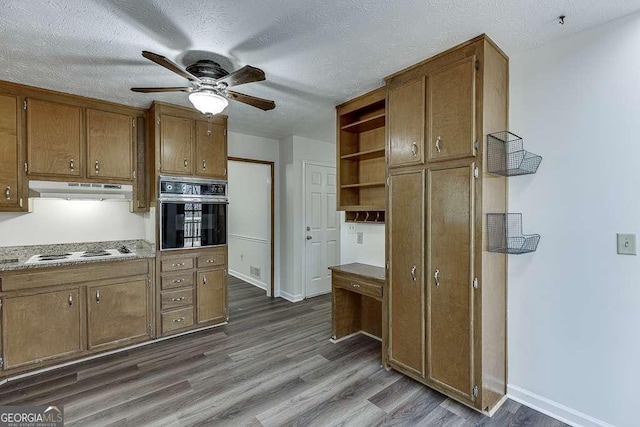 kitchen featuring ceiling fan, dark hardwood / wood-style floors, white electric cooktop, a textured ceiling, and black oven