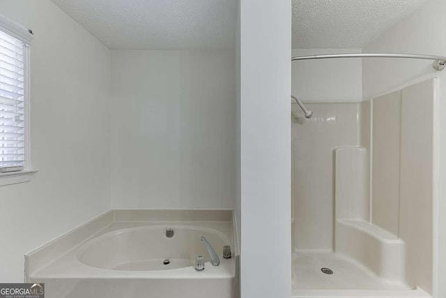 bathroom featuring a textured ceiling and a tub