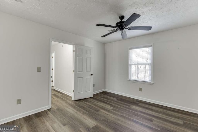 unfurnished room featuring ceiling fan, dark wood-type flooring, and a textured ceiling