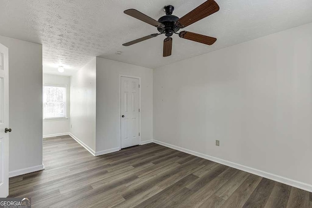 unfurnished room featuring a textured ceiling and dark wood-type flooring