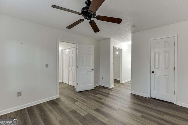 unfurnished bedroom with ceiling fan, dark hardwood / wood-style floors, and a textured ceiling