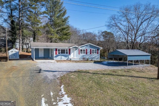 view of front facade with a storage shed, a carport, and a front yard