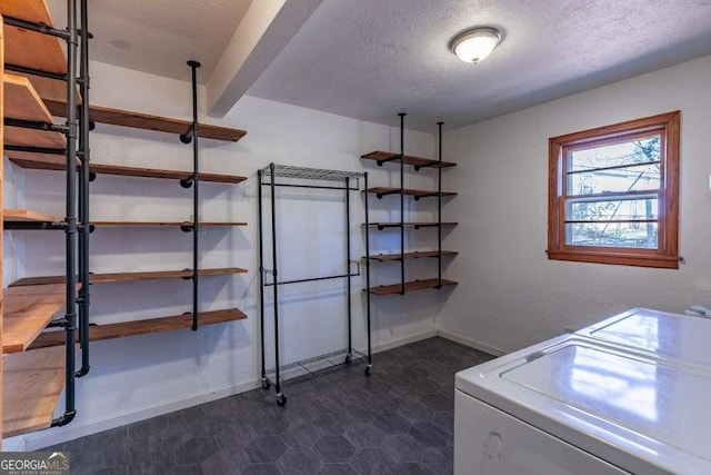 clothes washing area featuring a textured ceiling and washing machine and clothes dryer