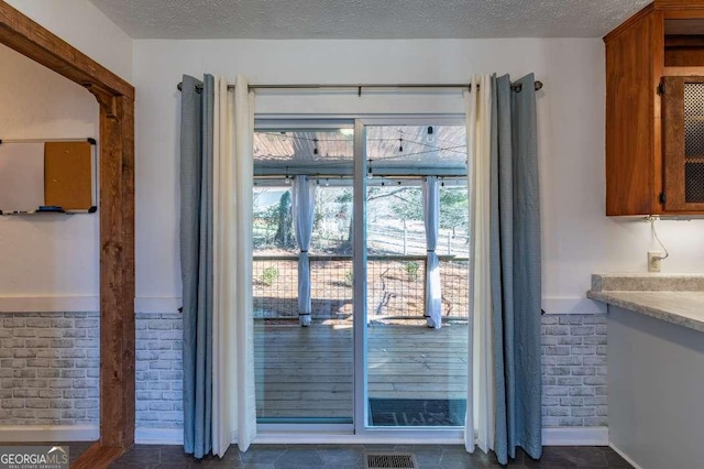 doorway to outside featuring a textured ceiling