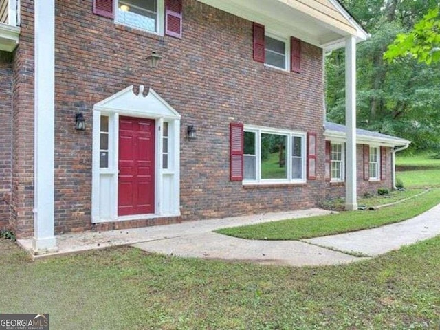 entrance to property featuring a lawn