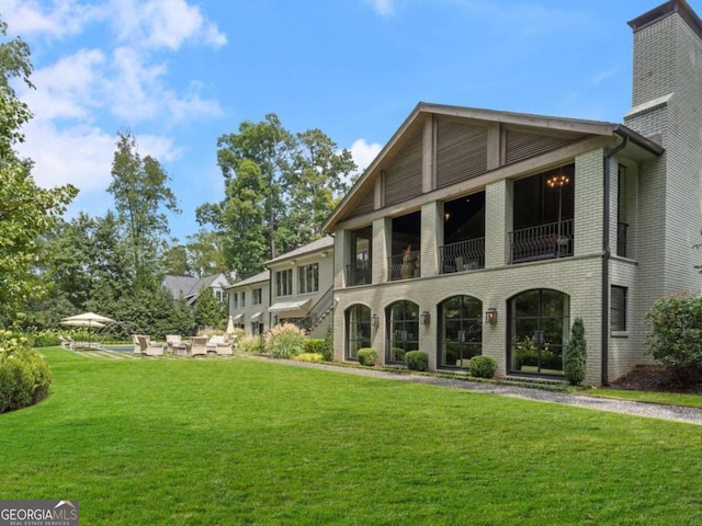 view of front of property featuring a patio area, a front yard, and brick siding