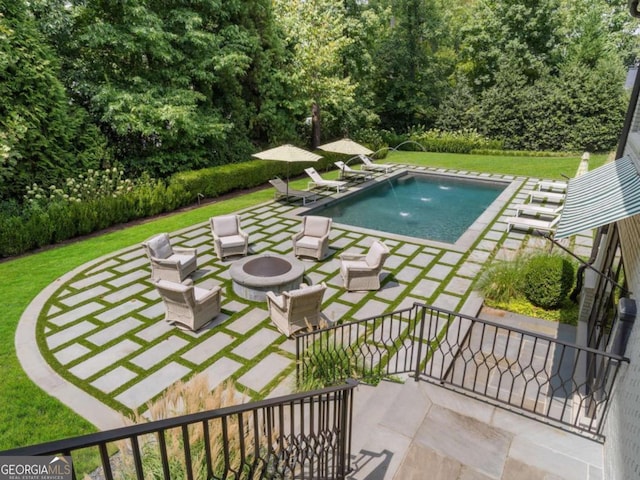 outdoor pool with a yard, an outdoor fire pit, and a patio