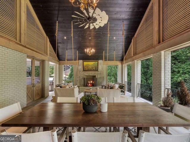 dining area with wood ceiling, a fireplace, high vaulted ceiling, and a notable chandelier