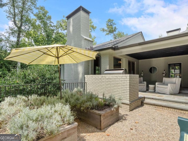 exterior space featuring brick siding, a patio area, and fence