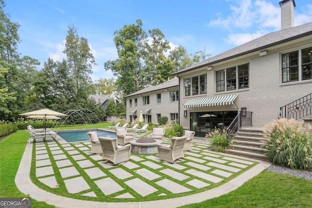 exterior space featuring a patio area, a yard, and a fire pit