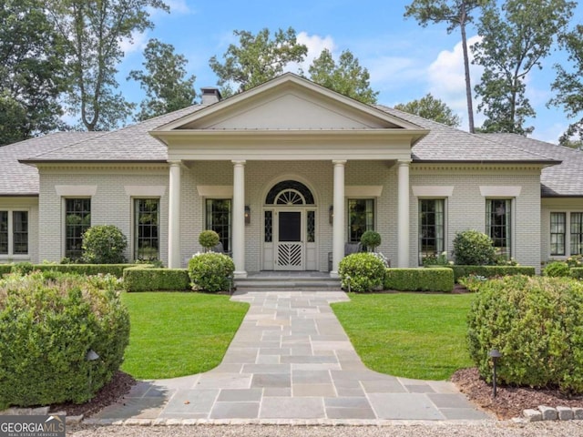 greek revival inspired property with a front lawn