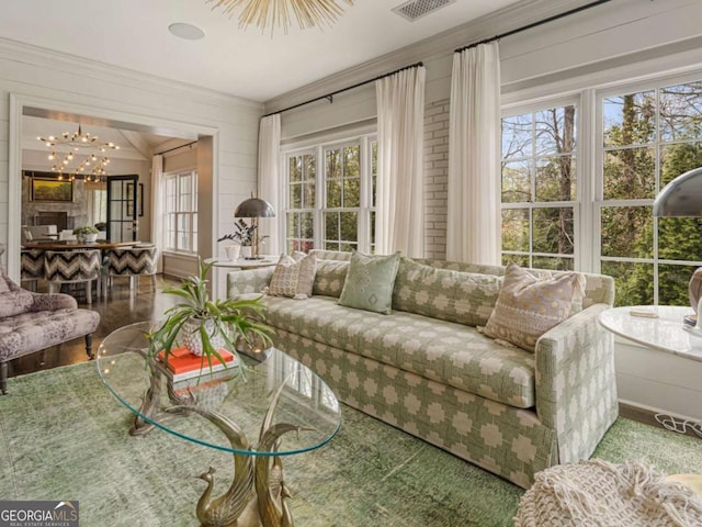 sunroom / solarium featuring a wealth of natural light and an inviting chandelier