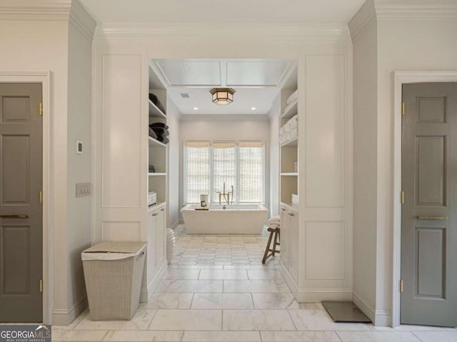 full bathroom with baseboards, a freestanding bath, built in features, and crown molding