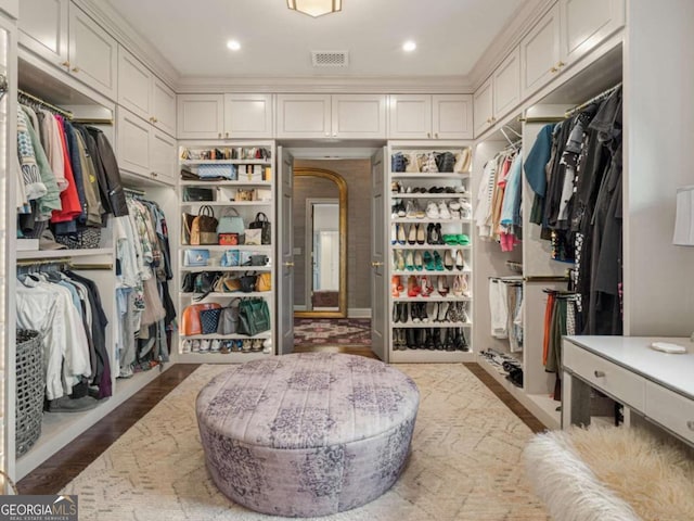 spacious closet featuring wood finished floors and visible vents