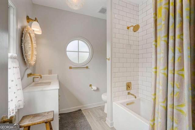 bathroom with toilet, wood finished floors, visible vents, baseboards, and shower / bath combination with curtain