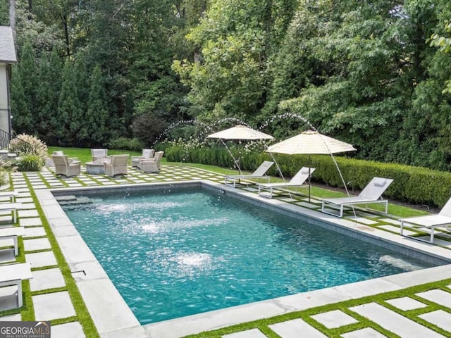 outdoor pool with a patio area and an outdoor living space