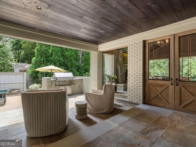 view of patio / terrace with exterior kitchen, area for grilling, and fence