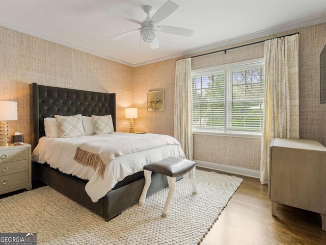 bedroom featuring wallpapered walls, baseboards, a ceiling fan, wood finished floors, and crown molding