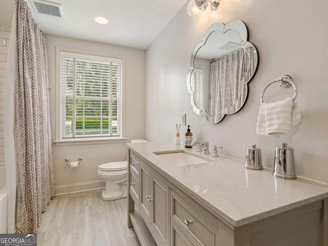 full bathroom with toilet, shower / bath combo, wood-type flooring, and vanity