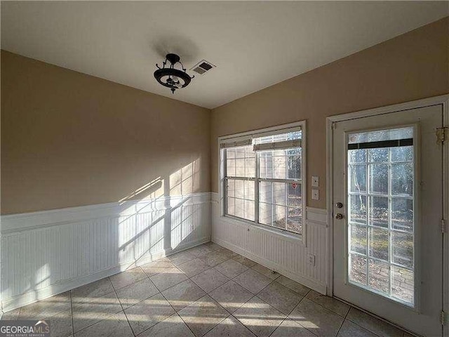 doorway to outside with light tile patterned floors