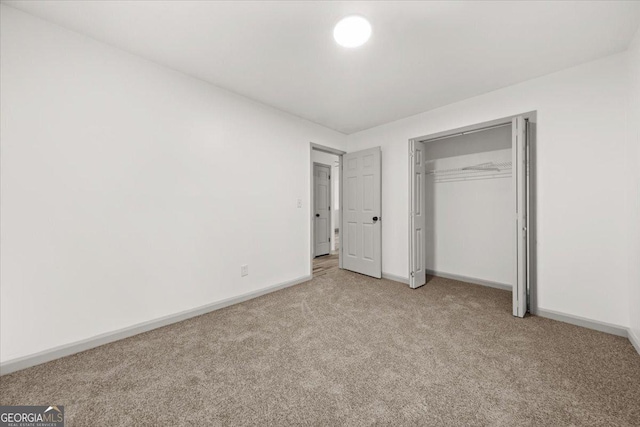 unfurnished bedroom featuring a closet and light colored carpet