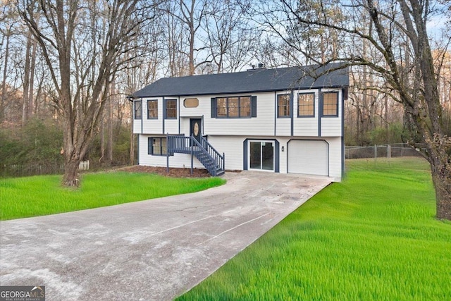 raised ranch featuring a front lawn and a garage