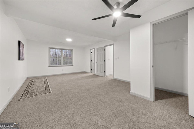 unfurnished bedroom with ceiling fan, light colored carpet, and a closet