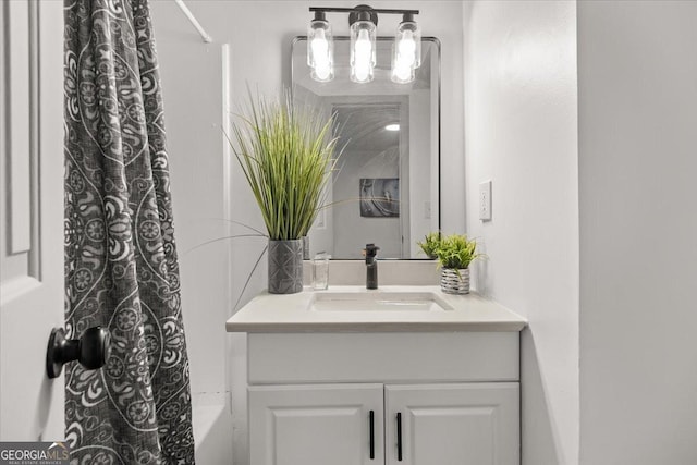 bathroom featuring shower / bath combo with shower curtain and vanity