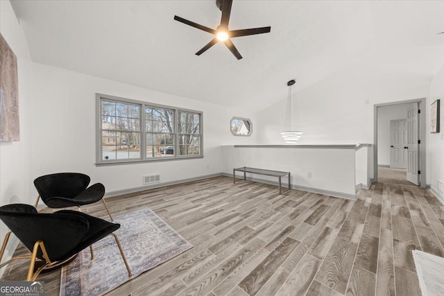 living area with ceiling fan, light hardwood / wood-style floors, and high vaulted ceiling