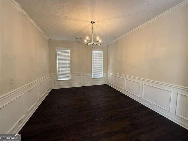 unfurnished dining area with an inviting chandelier, dark hardwood / wood-style flooring, a textured ceiling, and crown molding