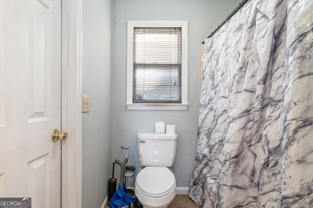 bathroom with a shower with curtain and toilet